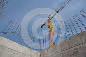 Tower crane and concrete base of the building. Construction crane on the background of the sky