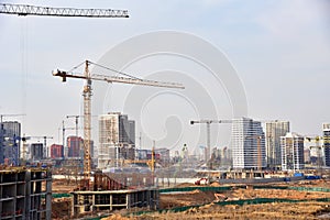 Tower crane on construction of a residential building. Cranes on formworks. Construction the building or multi-storey homes.