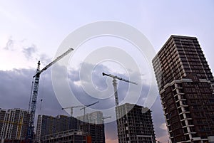 Tower crane on construction of a residential building. Cranes on formworks. Construction the building or multi-storey homes.