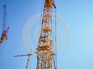 tower crane at the construction site against the background of the sky in summer