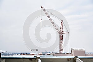 Tower crane at construction site against grey sky