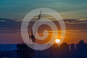 Tower crane on a construction site at sunrise