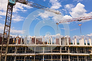 Tower crane at high concrete residential building under construction. Real estate development concept