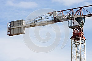 Tower crane machine, operators cab and load weights. Sky behind