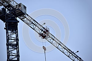 Tower crane near a house under construction in the city during the day