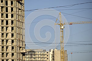 Tower crane near a house under construction in the city during the day