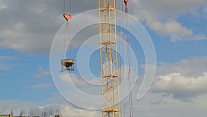 Tower crane raises and lowers materials for construction work on the building