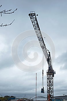 Tower crane silhouetted against a threatening sky