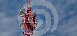 Tower crane soars into cloudy blue sky