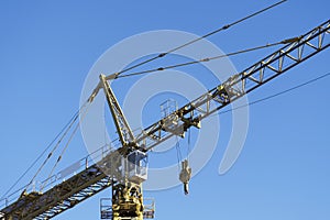 Tower crane tall high in sky yellow colour for construction site and shipbuilding close up of structure