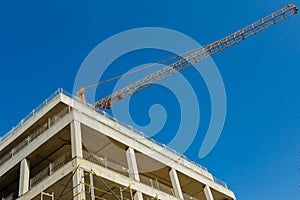 Tower crane and unfinished building an apartment house on a back