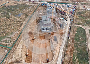 Tower cranes in action at construction site. Crane during formworks. Soil Compactor leveling ground for construct of foundation