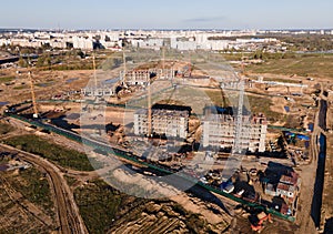 Tower cranes in action at construction site. Crane during formworks. Soil Compactor leveling ground for construct of foundation