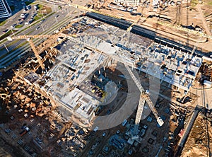 Tower cranes in action at construction site. Crane during formworks. Soil Compactor leveling ground for construct of foundation