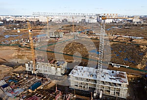 Tower cranes in action at construction site. Crane during formworks. Soil Compactor leveling ground for construct of foundation