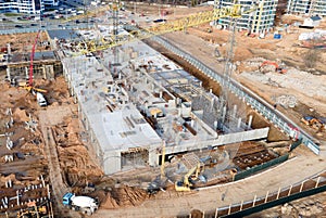 Tower cranes in action at construction site. Crane during formworks. Soil Compactor leveling ground for construct of foundation