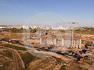 Tower cranes in action at construction site. Crane during formworks. Soil Compactor leveling ground for construct of foundation