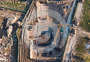 Tower cranes in action at construction site. Crane during formworks. Soil Compactor leveling ground for construct of foundation