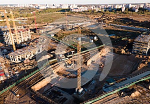 Tower cranes in action at construction site. Crane during formworks. Soil Compactor leveling ground for construct of foundation