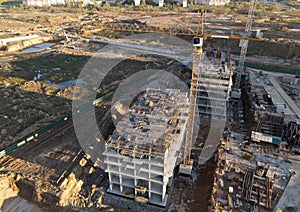 Tower cranes in action at construction site. Crane during formworks. Soil Compactor leveling ground for construct of foundation