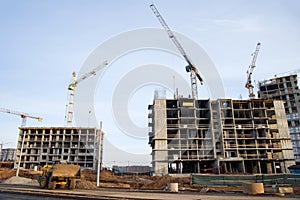 Tower cranes constructing a new residential build. Pouring concrete into formwork of building.