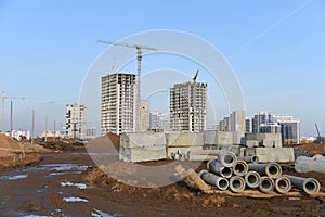 Tower cranes constructing a new residential build. Pouring concrete into formwork of building at construction site.