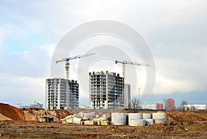 Tower cranes constructing a new residential build. Pouring concrete into formwork of building at construction site. Laying or