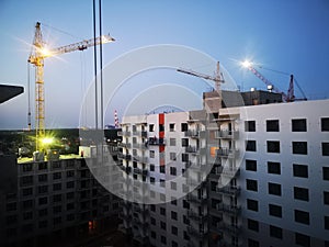 tower cranes at the construction site. Construction of apartments in a new residential complex