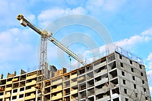 Tower cranes and new residential high-rise buildings at a huge construction site on background blue sky background.