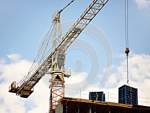 Tower cranes work during the construction of a multi-story building. New apartments for residents and premises for offices. Risky