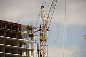 Tower cranes work during the construction of a multi-story building. New apartments for residents and premises for offices. Risky