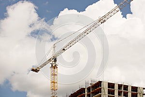 Tower cranes work during the construction of a multi-story building. New apartments for residents and premises for offices. Risky