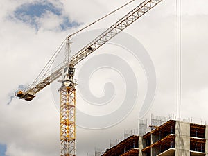 Tower cranes work during the construction of a multi-story building. New apartments for residents and premises for offices. Risky