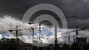 Tower cranes at work under thunderstorm in a district under construction in the suburbs of the city of Tallinn, Estonia