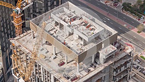 Tower cranes working on the construction site of new skyscraper high-rise building aerial timelapse. Dubai