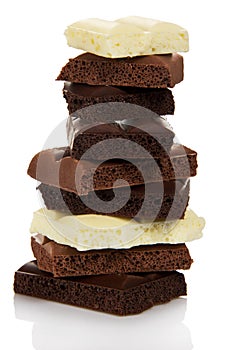 Tower of different pieces porous milk and black chocolate isolated.