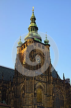 Tower with golden clock against blue sky. Saint Vitus Cathedral, Wenceslas and Adalbert Cathedral in Hradcany