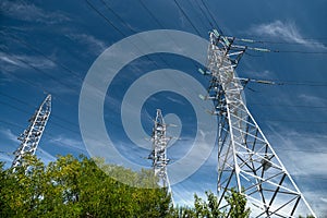 Tower with high-voltage energy transmission wires against the blue sky. High-voltage tower. Electrical wires and fuses