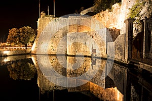 Tower and illuminated wall reflected in the water photo