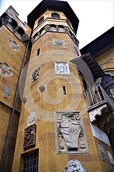 Tower, with large stone coat of arms and other smaller ones, of Villa Stibbert in Florence.