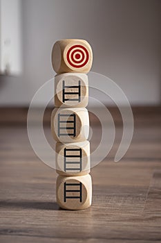 Tower made of Cubes, dice or blocks with a career ladder and target on wooden background