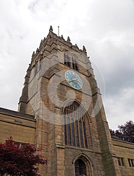 The tower of medieval bradford cathedral in west yorkshire with clock and windows