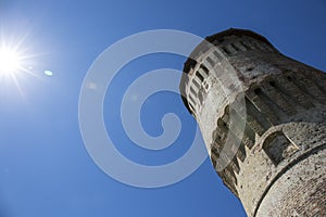 Tower of medieval italian castle on blue sky