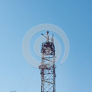 tower for mobile communication antennas against a blue sky with white clouds. Mobile operator antennas. Radio