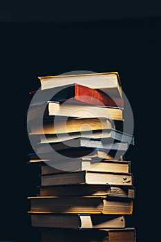 Tower Of Old Multi-colored Books On A Black Background. Concept Of Education And Knowledge