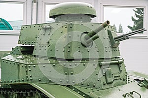 The tower of an old tank with a gun and a machine gun