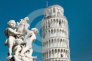 Tower of Pisa and statue of cherubs winged angels at sunny day, Italy
