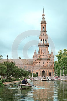 Tower of the Plaza de EspaÃÂ±a, Seville, next to boat navigating its canals