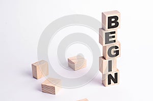 A tower of squares and cubes on a white background with the inscription begin. The beginning of something new