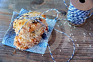 Tower stack of cookies with sesame seeds on blue napkin with a blue ribbon on wooden background. Biscuit background
